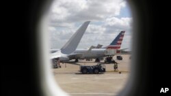 FILE- American Airlines aircraft sit at O'Hare International Airport in Chicago, June 16, 2018. Newer seat-back entertainment systems on some airplanes operated by American Airlines and Singapore Airlines have cameras, and it’s likely they are also on pla