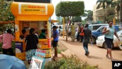 FILE - Ugandans use a mobile money point in Kampala, Uganda, Sept. 29, 2016.