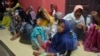Ethnic Rohingya women and children sit on the floor upon arrival at a temporary shelter after their boat landed in Pidie, Aceh province, Indonesia, Dec. 26, 2022.