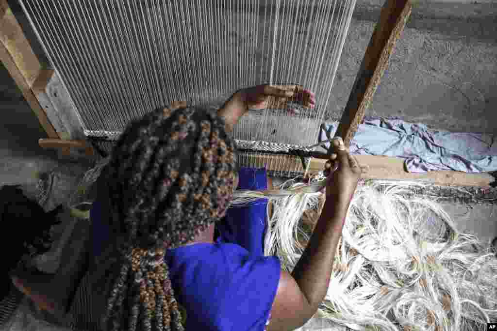 A worker weaves a carpet using banana fiber threads at TEXFAD factory in Sonde, Mukono District, Uganda, Sept. 20 2023.&nbsp;