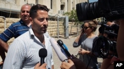Lebanese father Ali al-Amin speaks to journalists after dropping charges against his estranged wife and an Australian TV crew for attempting to kidnap their children, in front of the courthouse, in the Beirut southeastern suburb of Baabda, Lebanon, Wednes