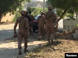 FILE - Paramilitary forces and police are seen during an attack on the Chinese Embassy in Karachi, Pakistan, Nov. 23, 2018.