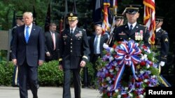 US President Donald Trump (L) is escorted for a ceremony to lay a wreath at the Tomb of the Unknown Soldier at Arlington National Cemetery, as part of Memorial Day observance, Arlington, Virginia, May 29, 2017. 