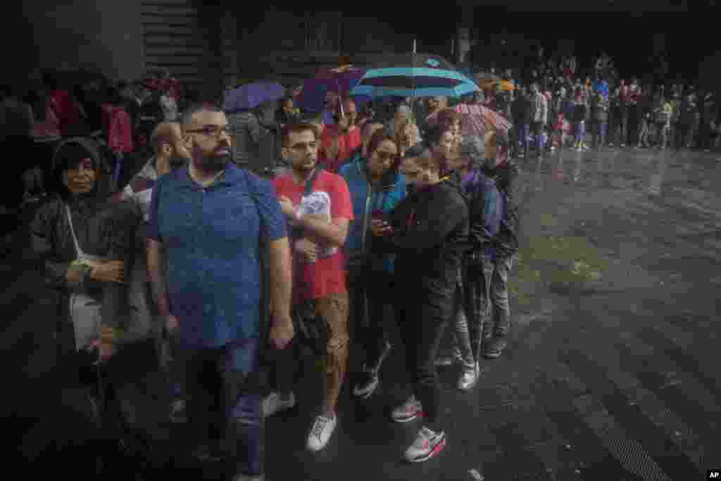 People queue to vote at a school listed to be a polling station by the Catalan government in Barcelona, Spain, Oct. 1, 2017. 
