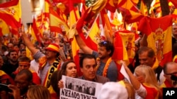 Demonstrators wave Spanish flags as they gather near a headquarters of federal police in Barcelona, Spain, Sunday Oct. 8, 2017. (AP Photo/Francisco Seco)