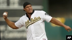 FILE - Former Oakland Athletics player Jose Canseco throws out the ceremonial first pitch prior to a baseball game against the Boston Red Sox in Oakland, Calif.