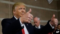 Republican presidential candidate Donald Trump gives thumbs up as he visits a caucus site Tuesday, Feb. 23, 2016.