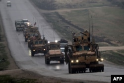 FILE - A convoy of U.S. military vehicles is seen in Syria's northern city of Manbij, Dec. 30, 2018.