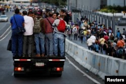 People ride in a truck and walk on a street during a blackout in Caracas, Venezuela, Feb. 6, 2018.
