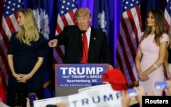 Republican U.S. presidential candidate Donald Trump, center, greets supports at a victory rally in Spartanburg, S.C., Feb. 20, 2016. On stage with Trump are his daughter, Ivanka, left, and his wife, Melania, right.