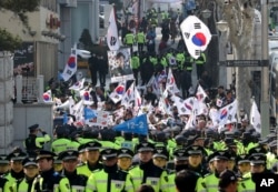Supporters of South Korean ousted President Park Geun-hye wave national flags and picture of Park outside of a prosecutors' office in Seoul, South Korea, March 21, 2017. Park said she was "sorry" to the people as she arrived Tuesday at a prosecutors' offi