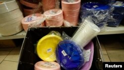 A basket filled with plastic plates and glasses