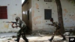 Somali government forces run in a street during skirmishes with insurgents from the al-Qaida aligned terrorist group Al-Shabaab in the Wardigley neighborhood in Mogadishu, Somalia (File)