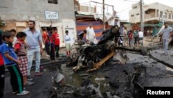 Warga bergabung di dekat serangan bom di distrik Kamaliya, Baghdad (20/5). 31 orang dilaporkan tewas dalam serangan bom di Baghdad dan Basra, Irak.