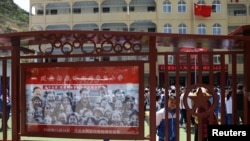 FILE - A picture of Chinese President Xi Jinping is seen at a primary school near Yangjialing Revolutionary Site, in Yanan, Shaanxi province, China, May 10, 2021.