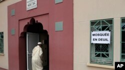 Seorang jamaah masjid berjalan melewati sebuah poster bertuliskan “Masjid Berduka” untuk melaksanakan sholat Jumat di Masjid Yahya, di Saint-Etienne-du-Rouvray. Normandy, Perancis (Foto: AP Photo/Francois Mori)
