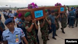 Indonesian military carry the caskets containing the bodies of two AirAsia Flight 8501 passengers recovered off the coast of Borneo, at a military base in Surabaya, Dec. 31, 2014. 