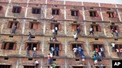 Indians climb the wall of a building to help students taking an examination in Hajipur, in India's Bihar state, March 18, 2015