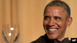 President Barack Obama laughs as actor and comedian Joel McHale speaks during the White House Correspondents' Association Dinner at the Washington Hilton Hotel, May 3, 2014, in Washington. 