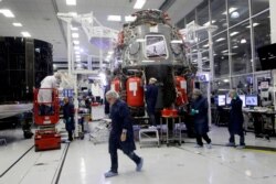SpaceX employees work on the Crew Dragon spacecraft that will astronauts to and from the International Space Station, from American soil, as part of the agency's commercial crew Program, in Hawthorne, Calif., Thursday, Oct. 10, 2019.
