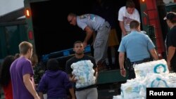 Volunteers unload drinking water from a truck outside Waite High School in Toledo, Ohio, August 3, 2014.