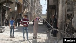 Residents inspect damages after an airstrike on the rebel held al-Maysar neighborhood in Aleppo, Syria, April 11, 2016. 