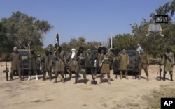 FILE - This file image taken from a video released, Oct. 31, 2014, by Boko Haram, shows Abubakar Shekau, center.