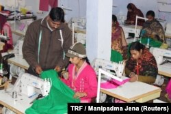 Mohammad Riyaz who set up a solar-powered garment manufacturing unit in Kamlapur village, in the Indian state of Uttar Pradesh, works with one of the 25 women who work for him stitching clothing, Jan. 9, 2018.