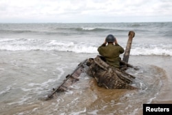 FILE PHOTO - A man in a wartime uniform poses for a photo on an abandoned tank at a beach ahead of the 60th anniversary of the Second Taiwan Straits Crisis against China, in Kinmen, Taiwan August 19, 2018.
