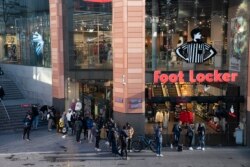 Warga antre di luar toko di Liverpool, Inggris, Senin, 12 April 2021, setelah pemerintah melonggarkan lockdown.