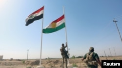 A member of Iraqi security forces takes down the Kurdish flag in Kirkuk, Iraq, Oct. 16, 2017. 