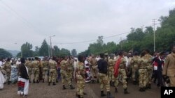 Ethiopian soldiers block the street as people march during an annual religious festival in Bishoftu, a town southeast of Ethiopia's capital, Addis Ababa, Sunday, Oct. 2, 2016.
