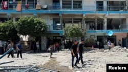 Палестинци го проверуваат местото на израелскиот напад врз училиштето на ОН во кое се засолнуваат раселените лица