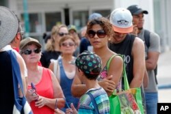 People wait in line to withdraw cash at a bank in the aftermath of Hurricane Maria, in San Juan, Puerto Rico, Sept. 27, 2017.