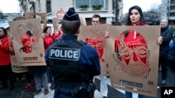 Members of Reporters Without Borders hold stencils representing portraits of detained Turkish journalists, during a demonstration in front of the Turkish embassy, in Paris, Jan. 5, 2018. 