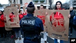 Members of Reporters Without Borders hold stencils representing portraits of detained Turkish journalists, during a demonstration in front of the Turkish embassy, in Paris, Jan. 5, 2018.