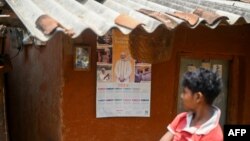 FILE - A boy looks at a calendar with a portrait of India's Prime Minister Narendra Modi in Tatem village some 43 Km (27 miles) from Dantewada town in Chhattisgarh state on April 16, 2024.