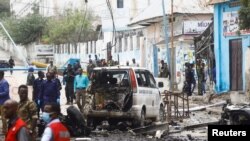 Petugas keamanan berkumpul di lokasi ledakan bom mobil bunuh diri di persimpangan jalan dekat kediaman presiden, di Mogadishu, Somalia, 25 September 2021. (Foto: REUTERS/Feisal Omar)