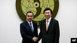 왕이 중국 외교부장(왼쪽)이 26일 한-중 외교장관 회담을 위해 외교부 청사를 방문, 회담에 앞서 윤병세 외교부 장관과 악수하고 있다. (자료사진)