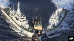 Dua kapal pengawal pantai Jepang mengelilingi perahu aktivis Tiongkok (tengah) yang berusaha menuju kepulauan Senkaku yang disengketakan (foto: dok). 