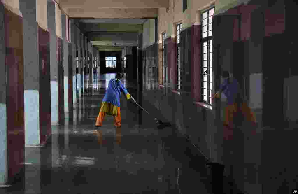 An Indian worker cleans the corridor of the Modern Government Maternity Hospital in Hyderabad, India, Nov.12, 2014.