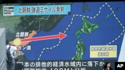 FILE - People walk past a public TV screen broadcasting news of North Korea's launch of its second intercontinental ballistic missile, in Tokyo, July 29, 2017.