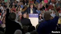 Audience members raise their hands to ask U.S. Republican presidential candidate Donald Trump a question at a campaign town hall meeting in Rochester, New Hampshire September 17, 2015.