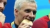 American swimmer Ryan Lochte bites into his gold medals after the men's 4x200m freestyle relay final in the Rio 2016 Summer Olympic Games in Rio de Janeiro, Aug. 9, 2016. (Jason Getz-USA TODAY Sports )