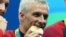 American swimmer Ryan Lochte bites into his gold medals after the men's 4x200m freestyle relay final in the Rio 2016 Summer Olympic Games in Rio de Janeiro, Aug. 9, 2016. (Jason Getz-USA TODAY Sports )
