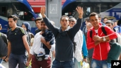 Para migran tampak gembira begitu sampai di stasiun kereta api di Munich, Jerman, Sabtu (5/9).