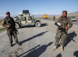 FILE - Afghan National Army soldiers stand guard at a checkpoint near the Bagram Airbase north of Kabul, Afghanistan, April 2, 2020. Battlefield violence between pro-Afghan government forces and the Taliban insurgency has surged since May 1, 2021.