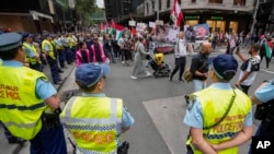 Police watch as protesters march during a pro-Palestinian rally in Sydney, Australia, Nov. 4, 2023, in support of Palestinians caught up in the war between Israel and Hamas. 