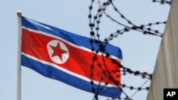 Bendera Korea Utara berkibar di belakang kawat berduri di atas tembok Kedutaan Besar Korea Utara di Kuala Lumpur, Malaysia, 13 Maret 2017. (Foto: dok).