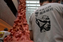 Para aktivis di kampus Universitas Hong Kong, membersihkan sisa-sisa dekorasi "Pilar Kesedihan Nasional" untuk memperingati korban Tiananmen. (AP).